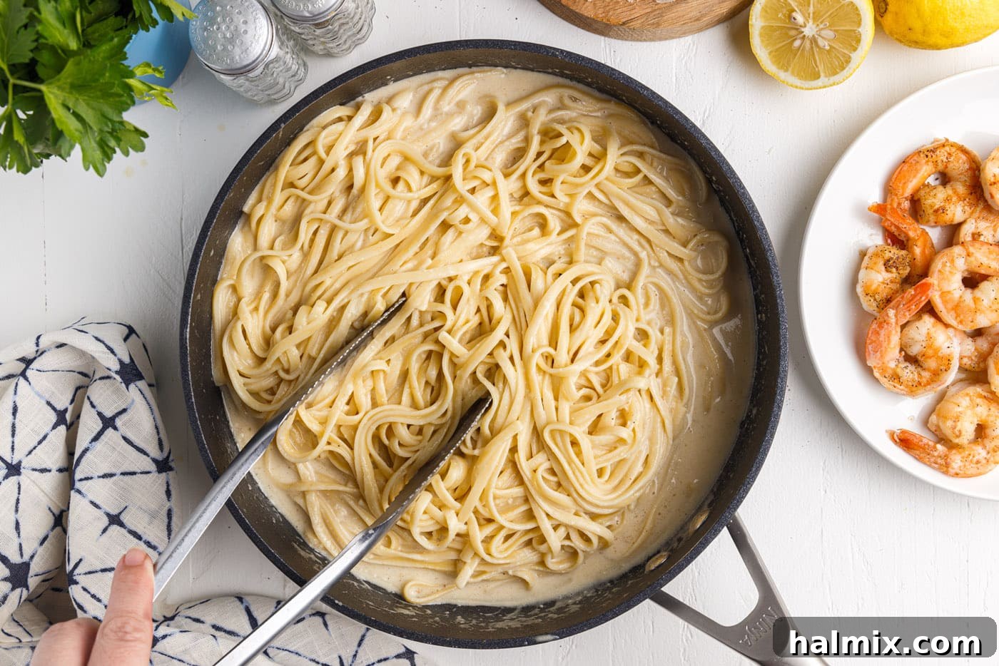 Creamy Garlic Shrimp Pasta 14 tossing linguine noodles in lemon garlic sauce in a skillet