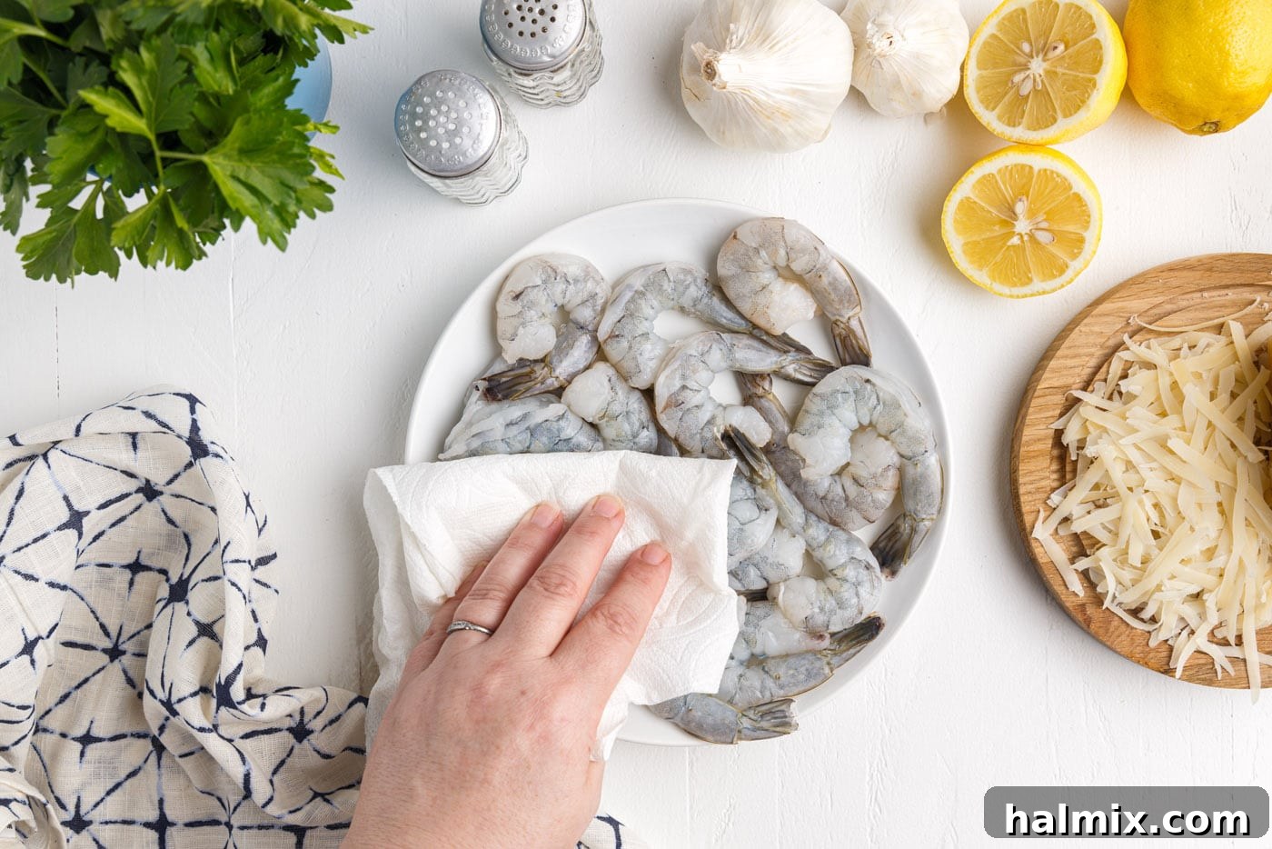 Creamy Garlic Shrimp Pasta 5 patting shrimp dry with a paper towel on a cutting board