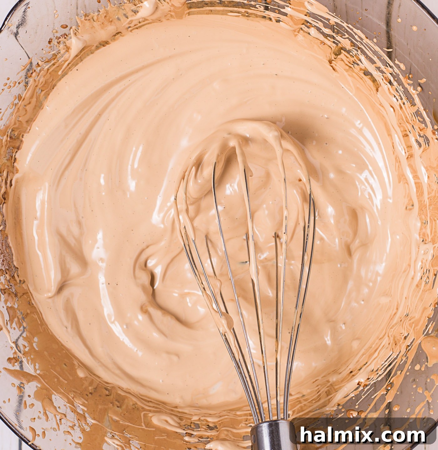 A bowl of perfectly whipped Dalgona coffee cream, light brown and holding its shape.