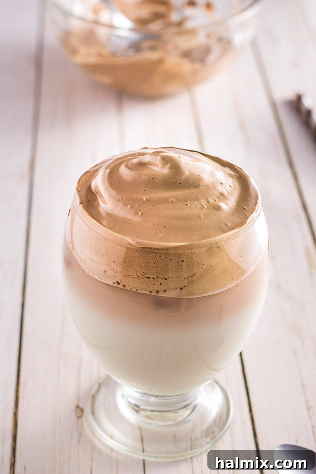 A beautifully prepared glass of Dalgona Coffee, topped with dense foam.
