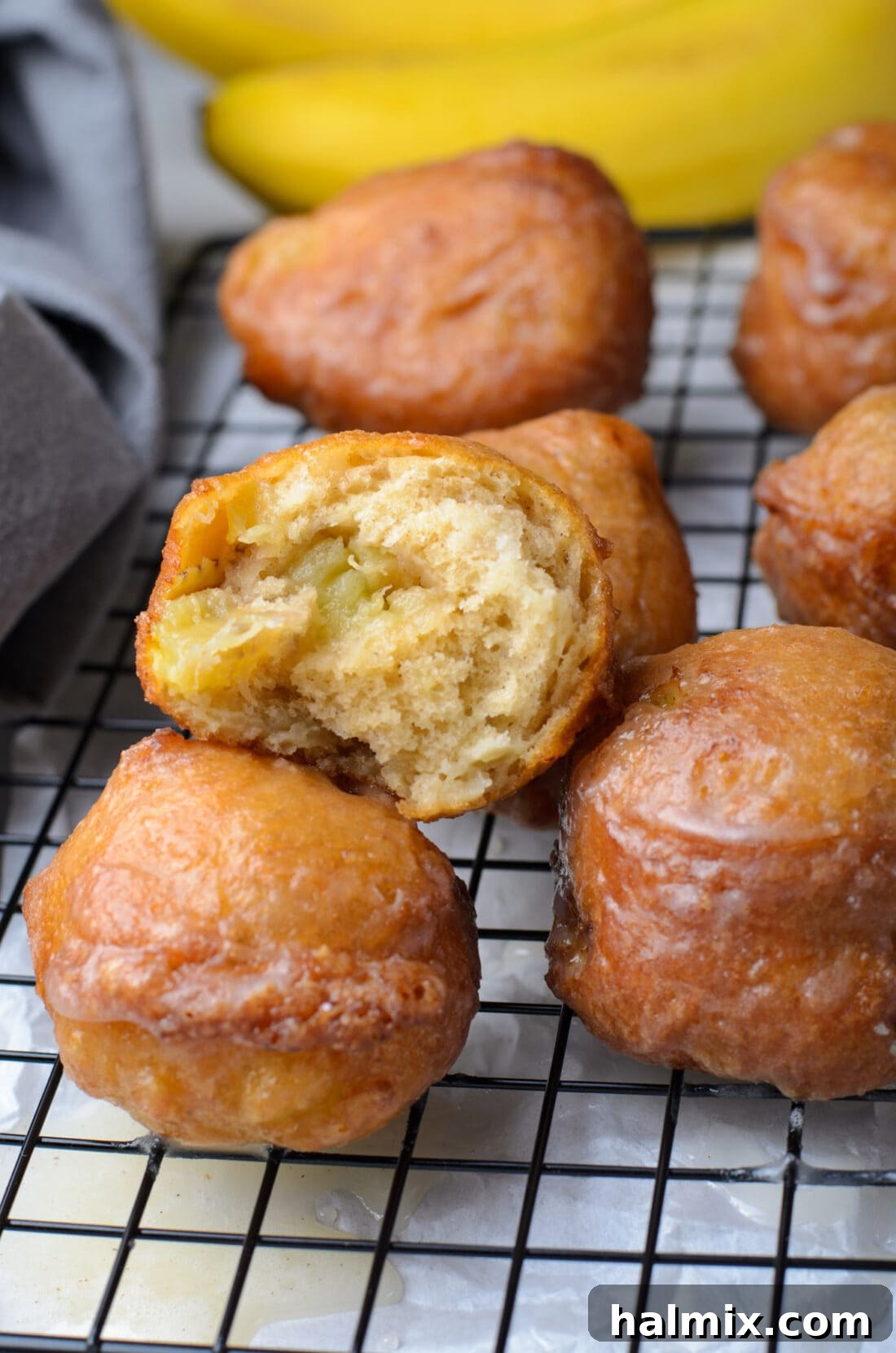 A bite taken out of a fluffy banana fritter, revealing its soft interior.