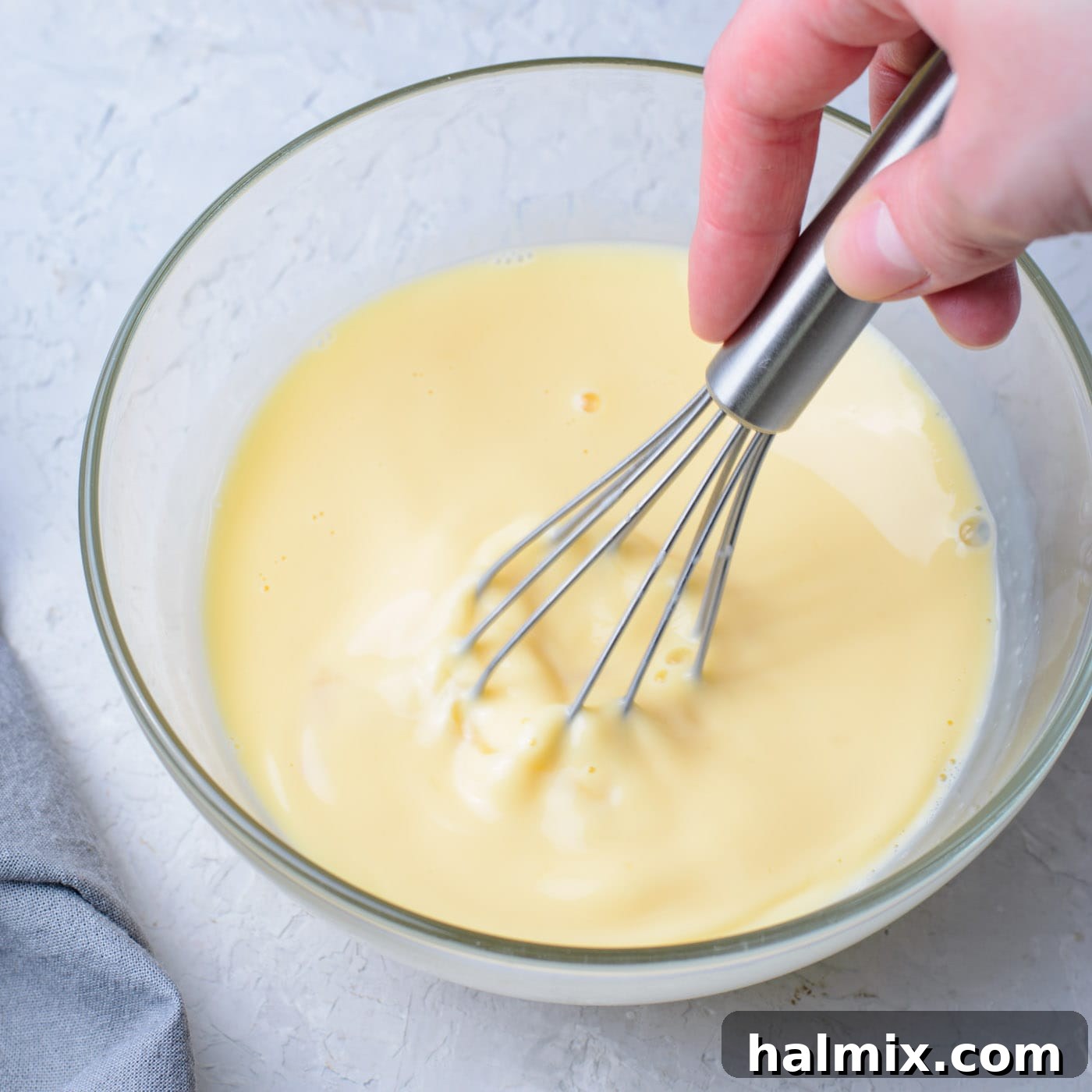 Eggs, vanilla, milk, and melted butter whisked together in a bowl.