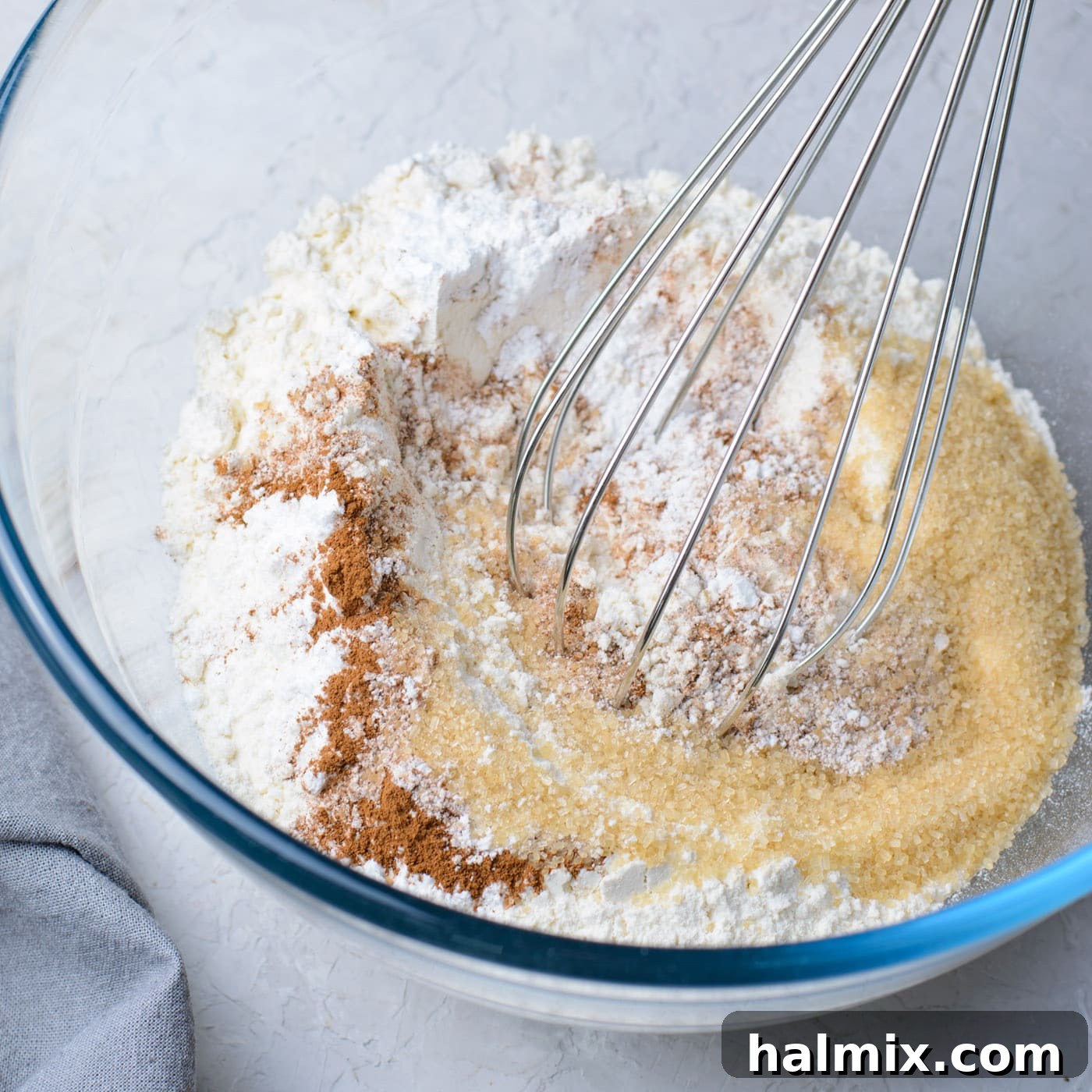 Flour, baking powder, brown sugar, salt, and cinnamon mixed in a bowl.