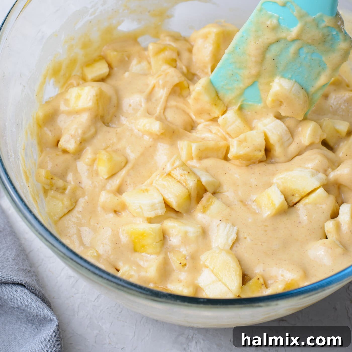Mixing chopped bananas into the prepared fritter batter.