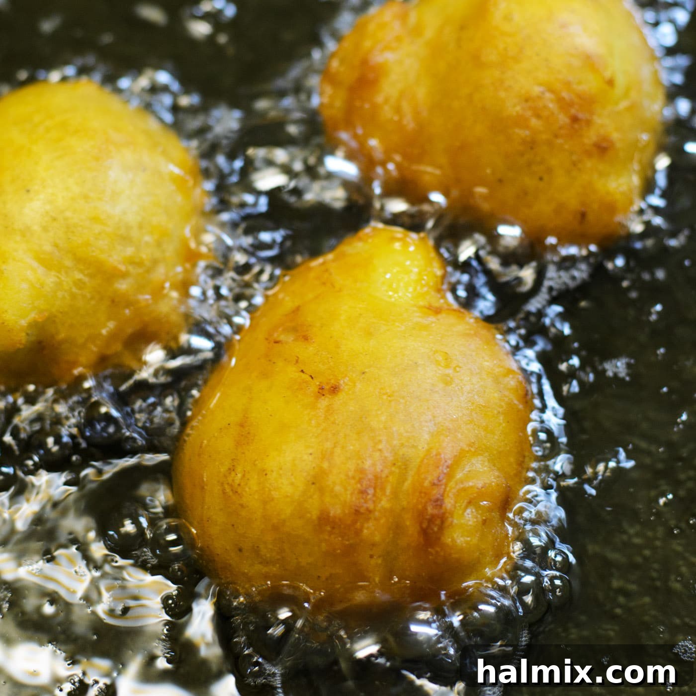 Frying banana fritters in a pan until golden brown and crispy.