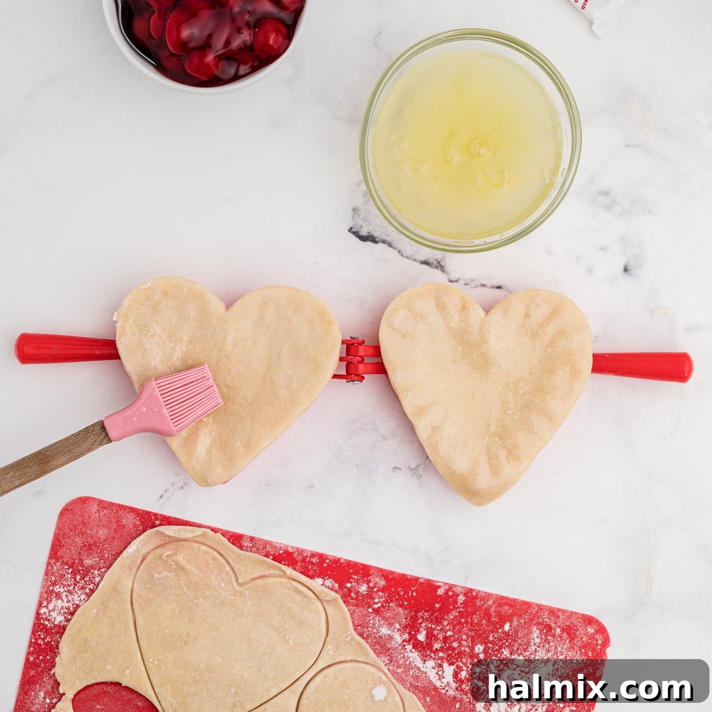 brushing heart shaped pie dough with egg wash