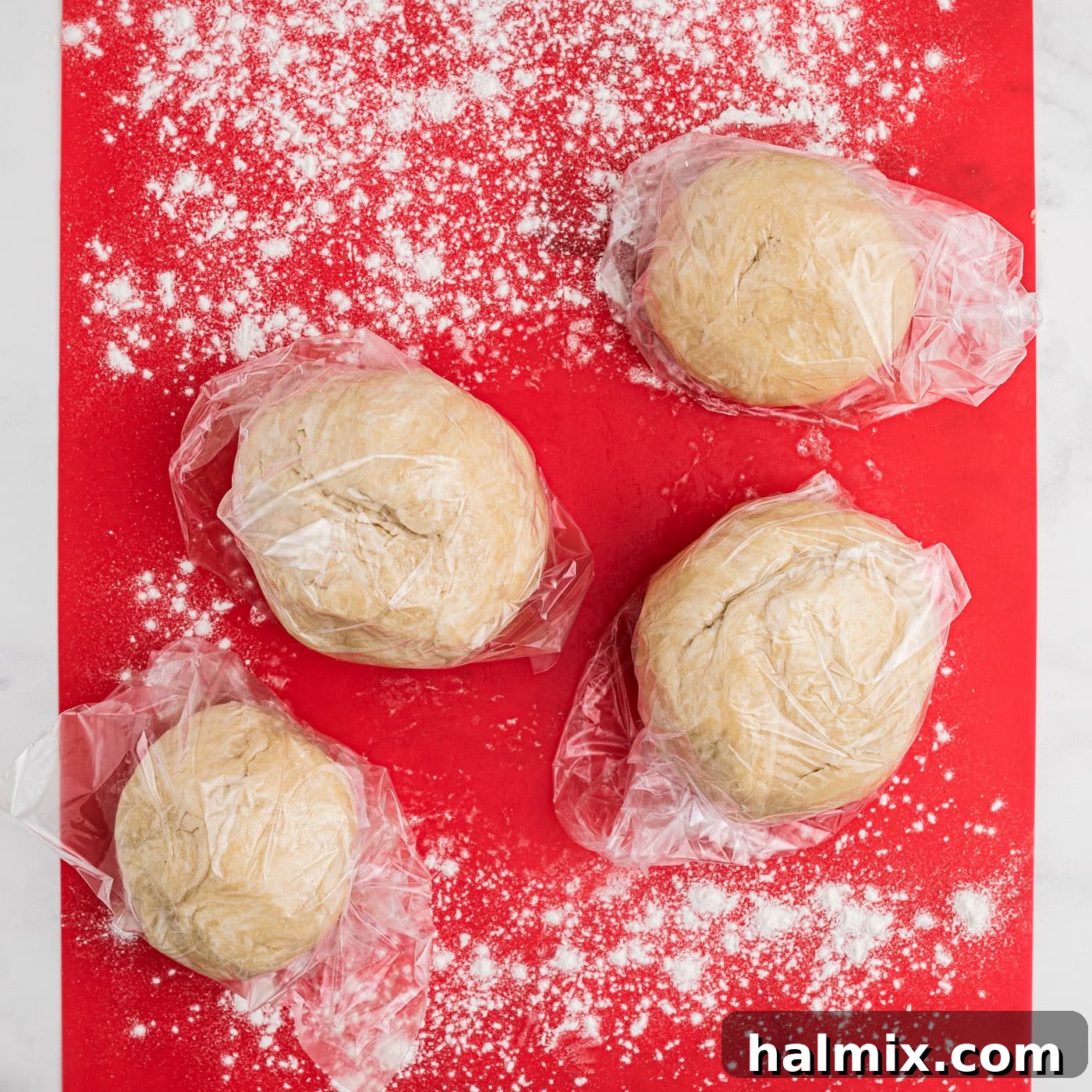 small pie dough balls on floured surface