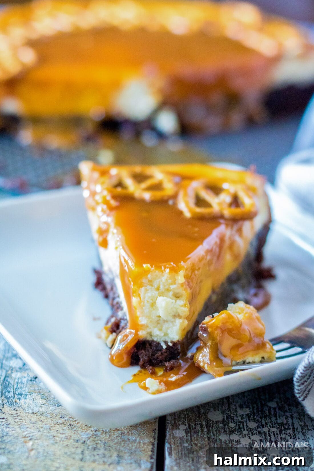 slice of Salted Caramel Cheesecake with bite out of it, revealing the brownie crust
