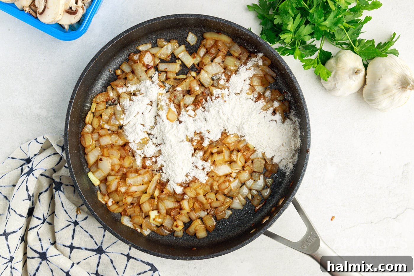 flour added to onions and garlic in a skillet