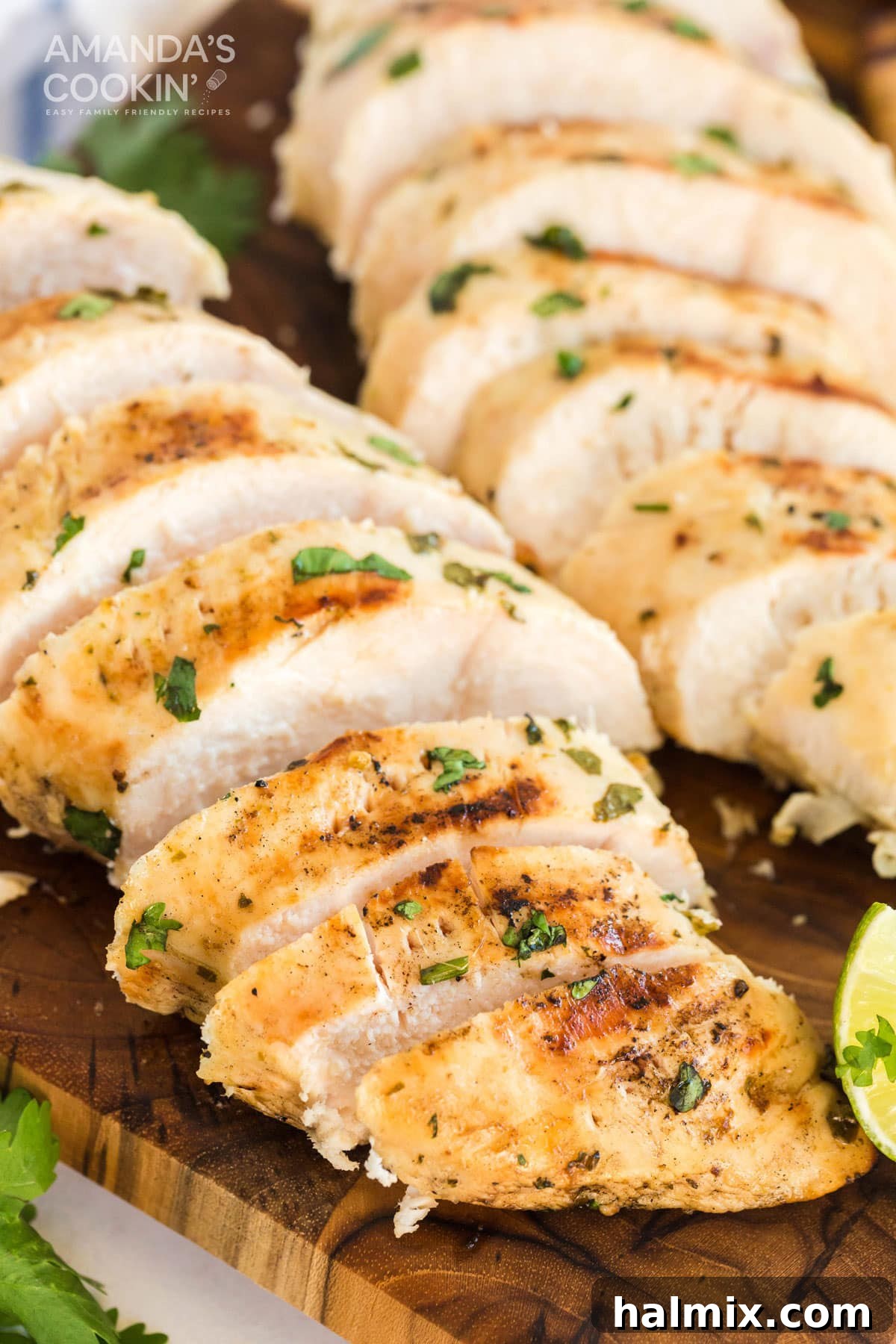 Sliced grilled cilantro lime chicken breasts arranged neatly on a wooden cutting board, ready to serve.
