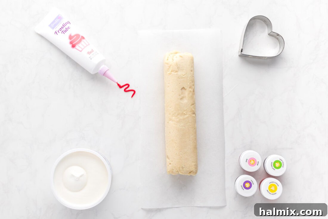 Assortment of ingredients for Conversation Heart Cookies, including cookie dough and colorful frostings