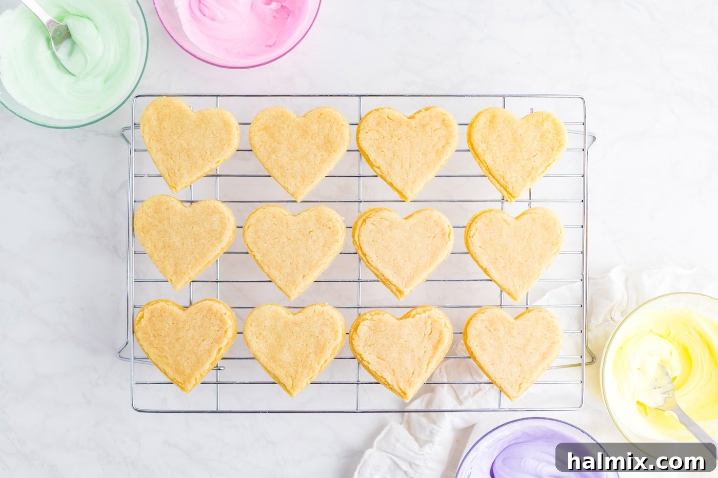 Freshly baked heart shaped sugar cookies cooling on a wire rack