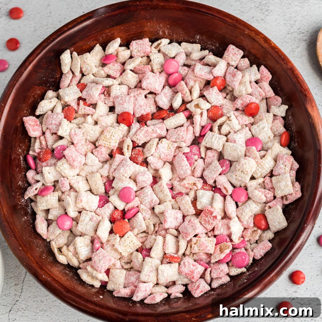Valentine Muddy Buddies in a festive white bowl, garnished with M&M's