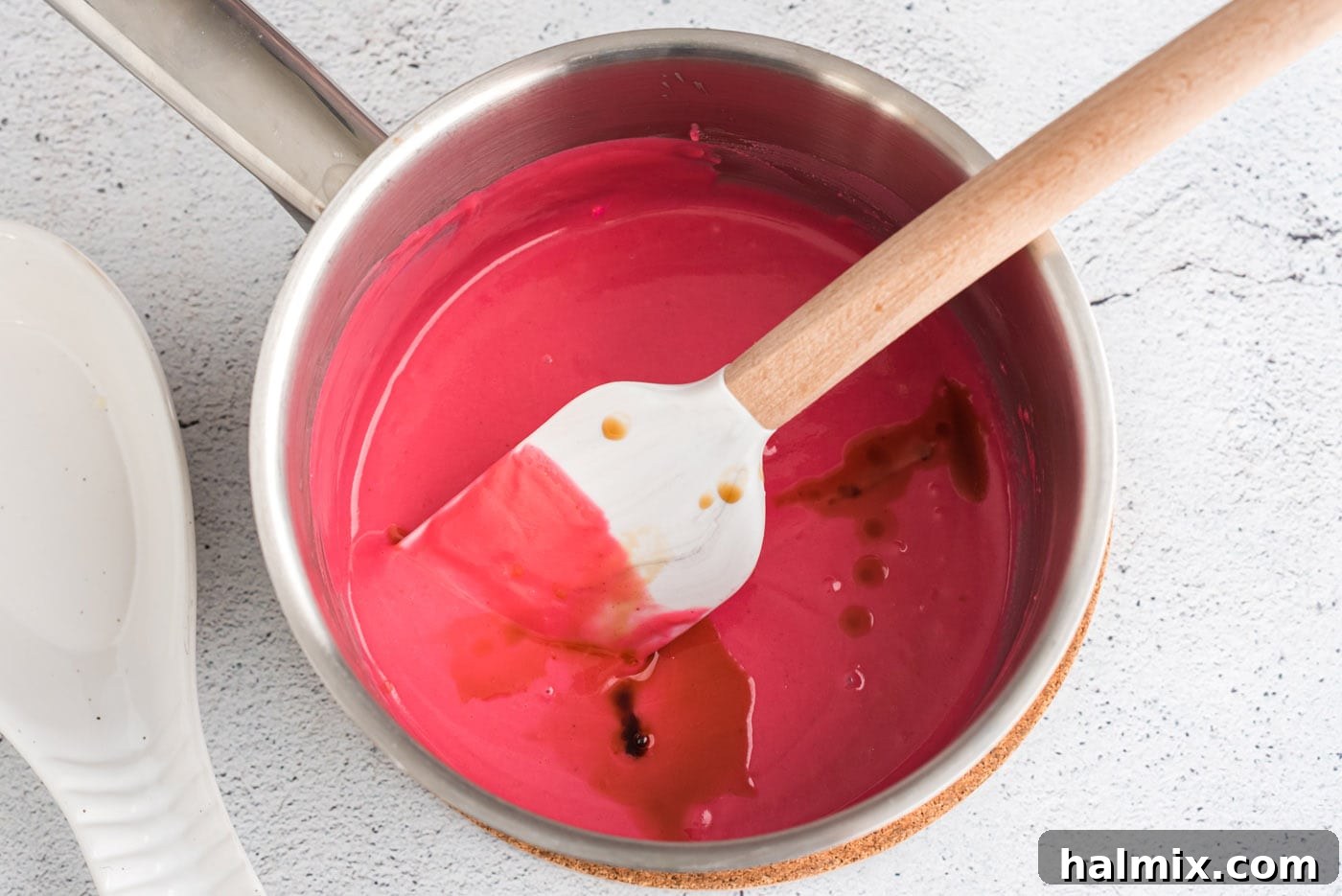Pink candy melts mixture with vanilla extract being added