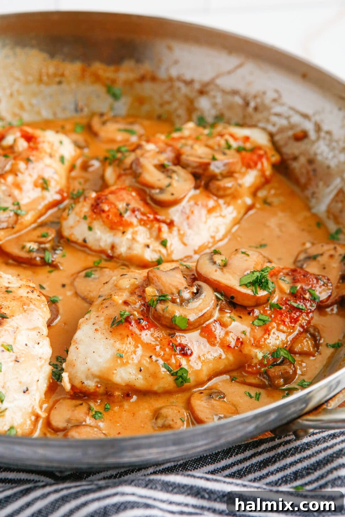 Chicken Marsala in a skillet, showcasing golden-brown chicken and rich sauce.
