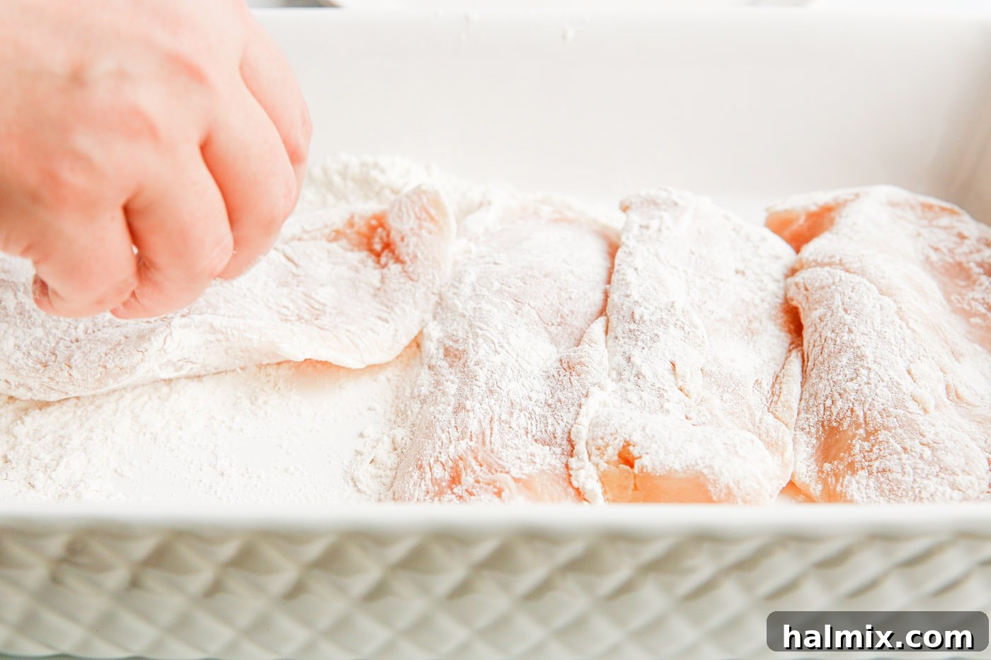 Chicken cutlets lightly coated with flour, ready for pan-frying.