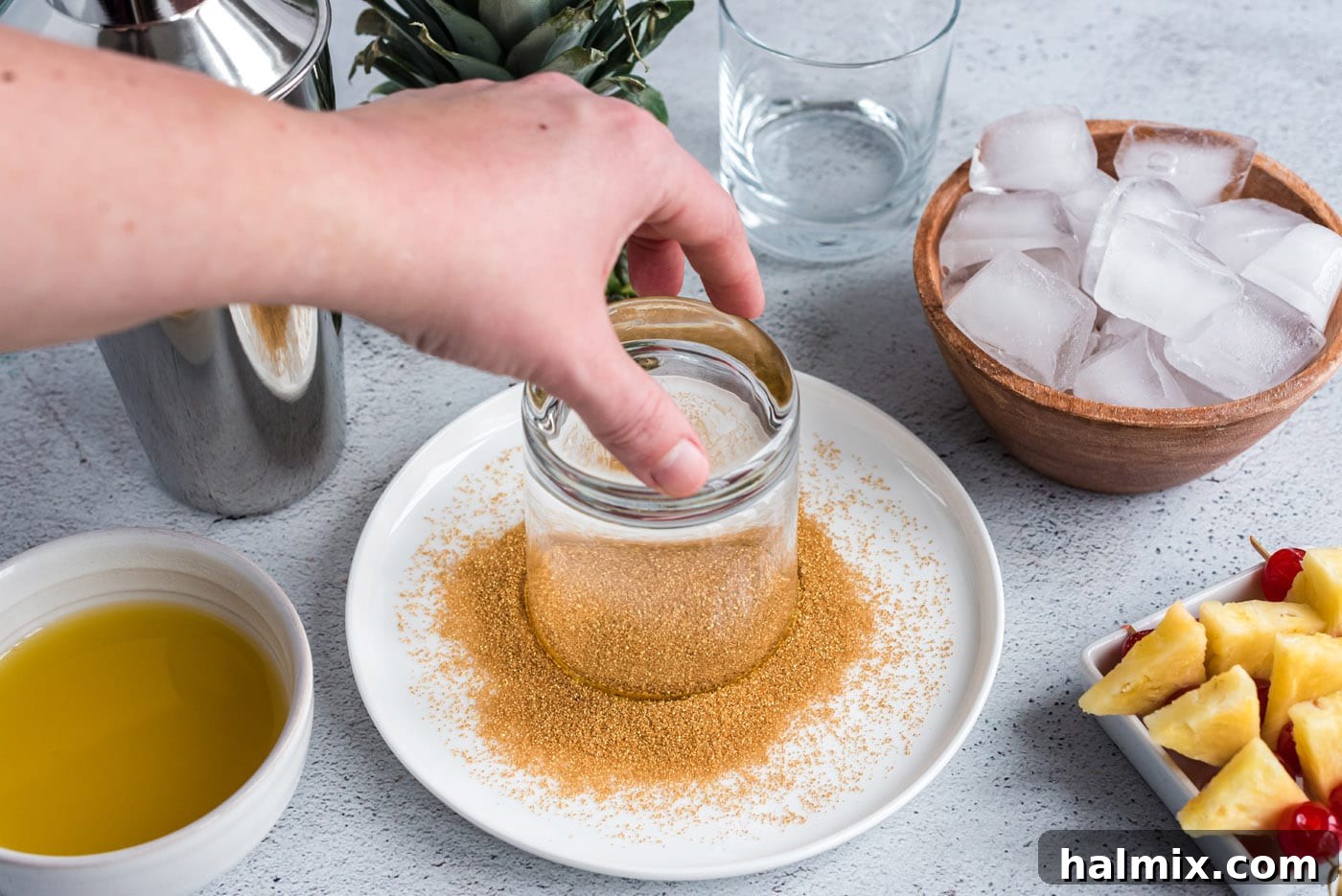 dipping glass into sanding sugar