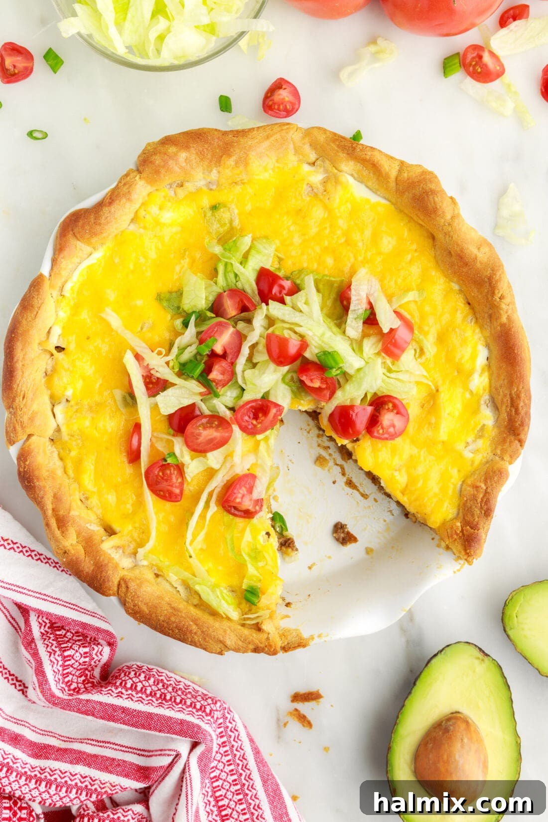 Ultimate Taco Casserole 2 Overhead view of a freshly baked Taco Pie, sliced and ready to serve, showcasing the vibrant layers of meat, cheese, and toppings.