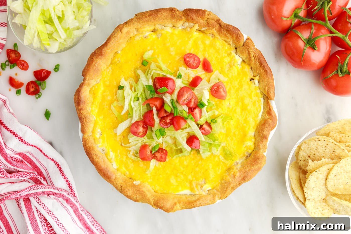 Ultimate Taco Casserole 13 A fully baked Taco Pie topped with fresh diced tomatoes and shredded lettuce, ready to be served.