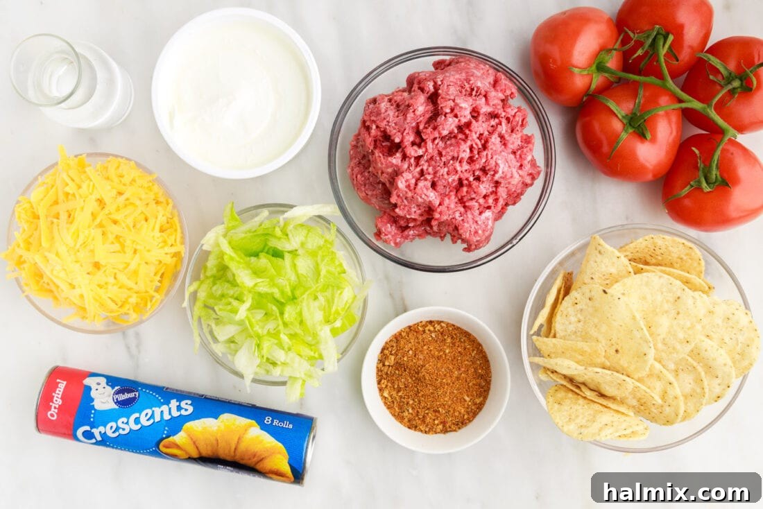 Ultimate Taco Casserole 4 A flat lay photograph displaying all the ingredients required to prepare a Taco Pie, neatly arranged on a rustic wooden surface.