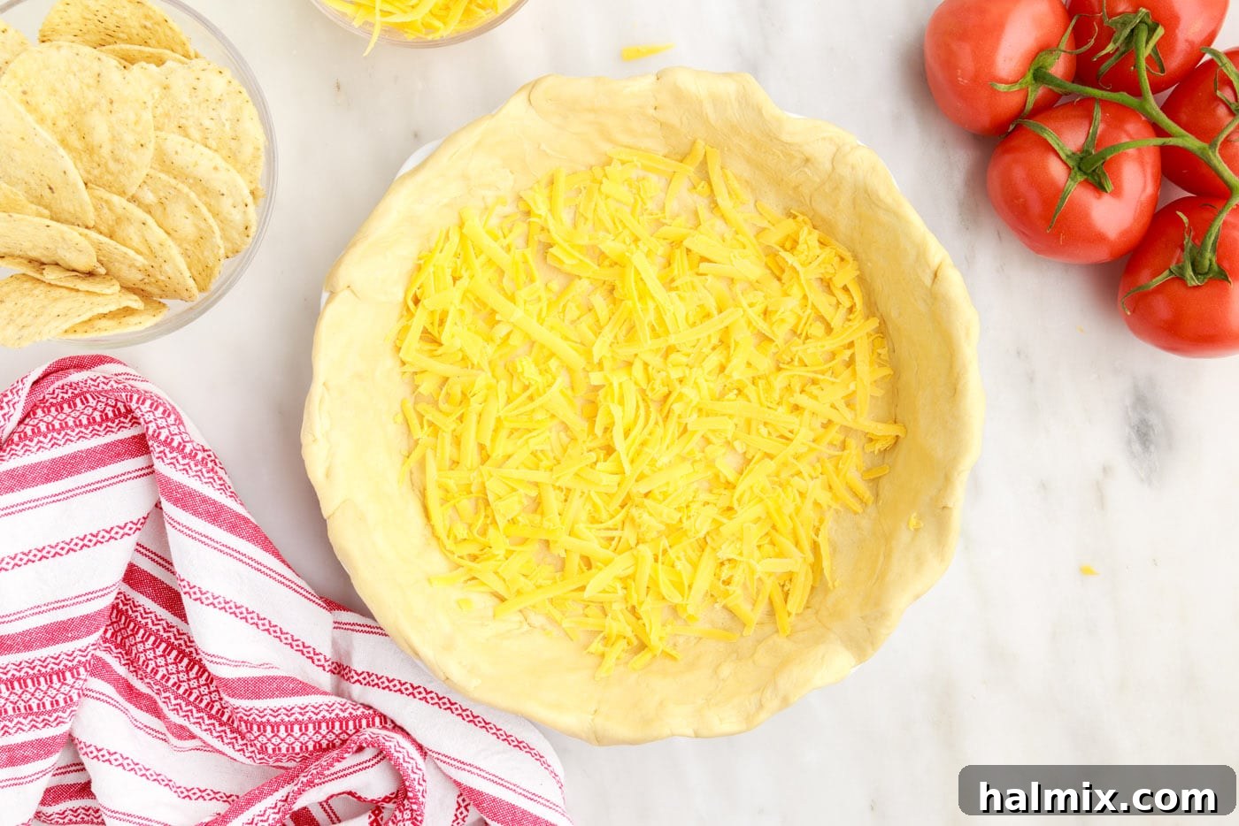 Ultimate Taco Casserole 7 A layer of shredded cheese sprinkled over the crescent roll dough at the bottom of the pie plate.