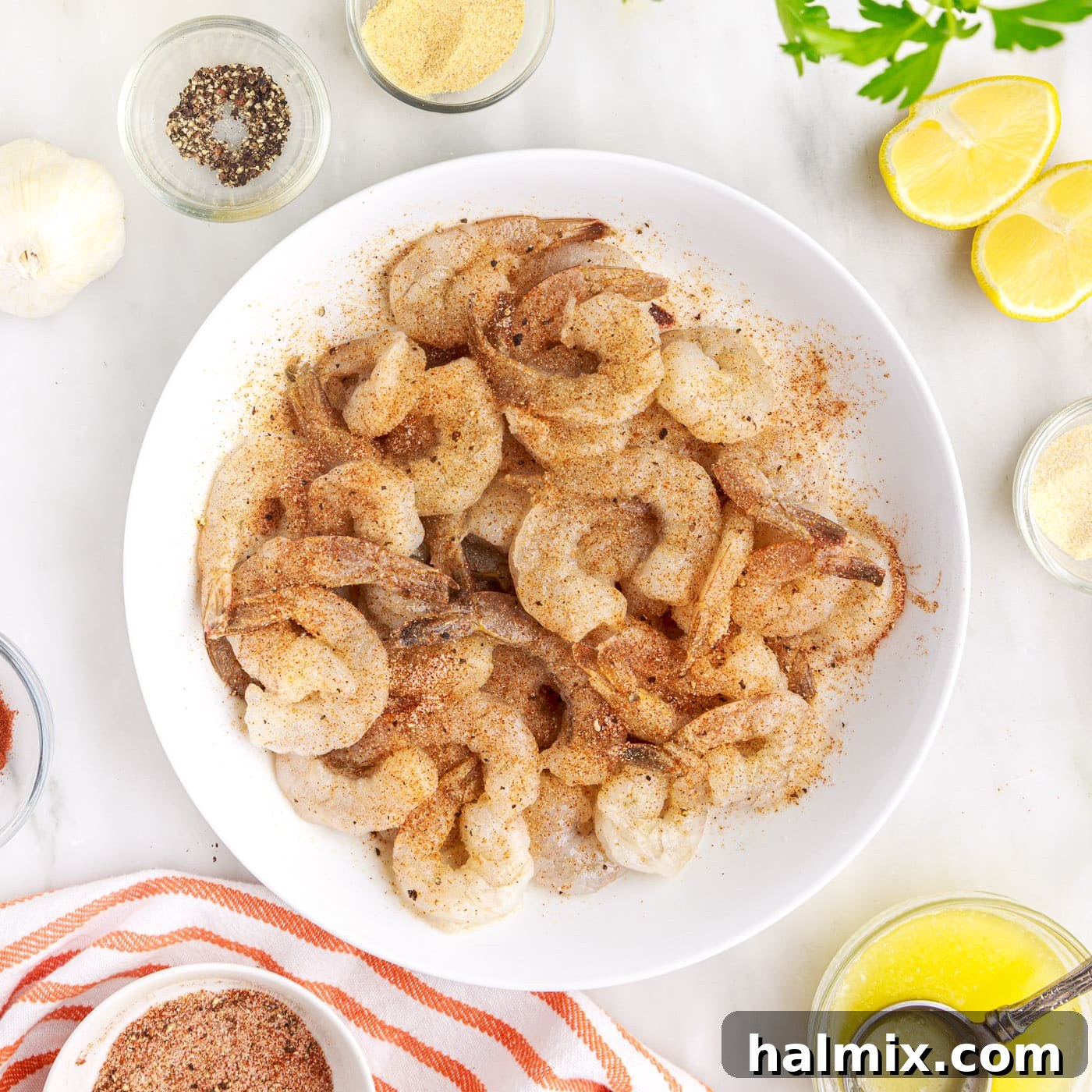 Crispy Air Fryer Shrimp 8 Seasoned shrimp ready for air frying, arranged on a plate.