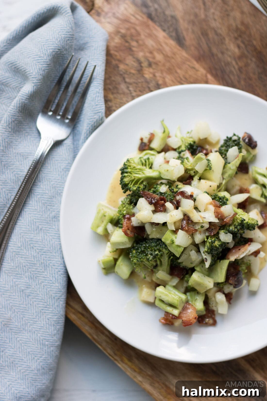 Creamy Broccoli Salad 6 A single serving of fresh broccoli salad on a white plate, garnished and ready to be enjoyed as a vibrant side dish.