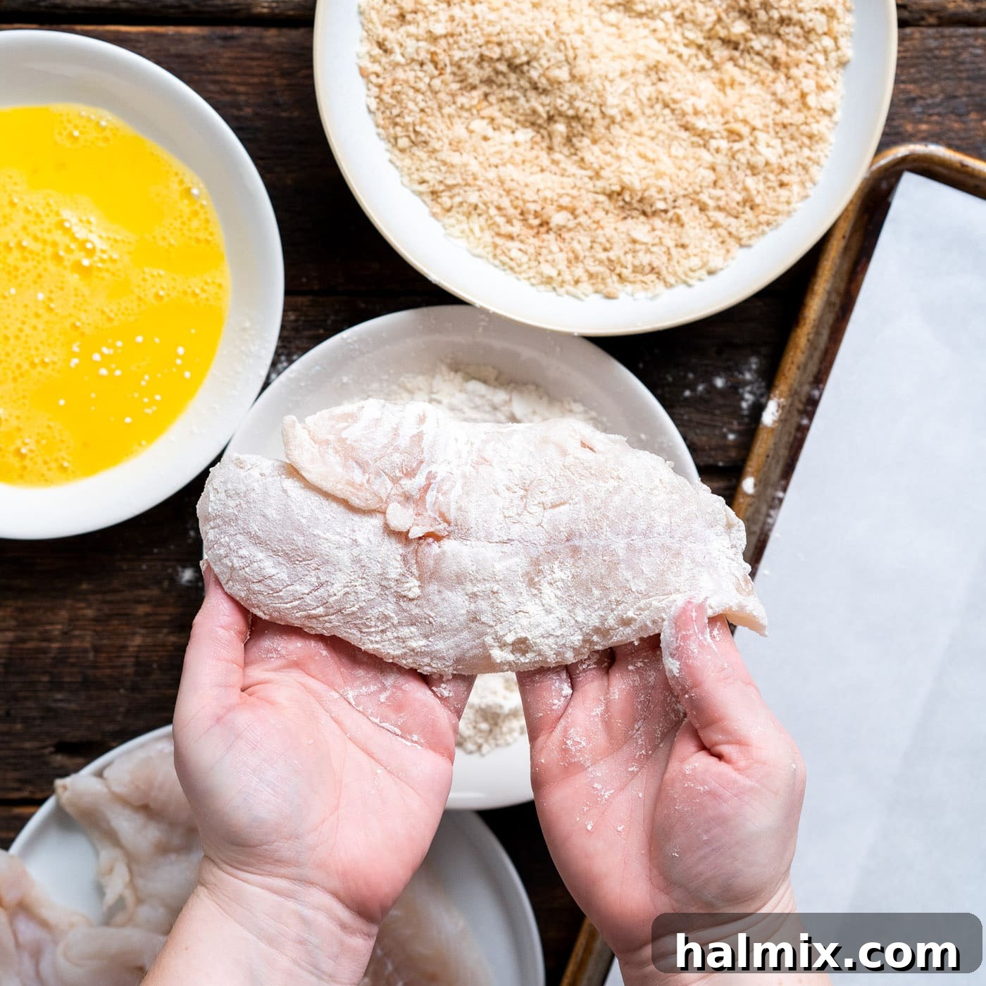 Cod fillet being coated in flour, the first step of the dredging process