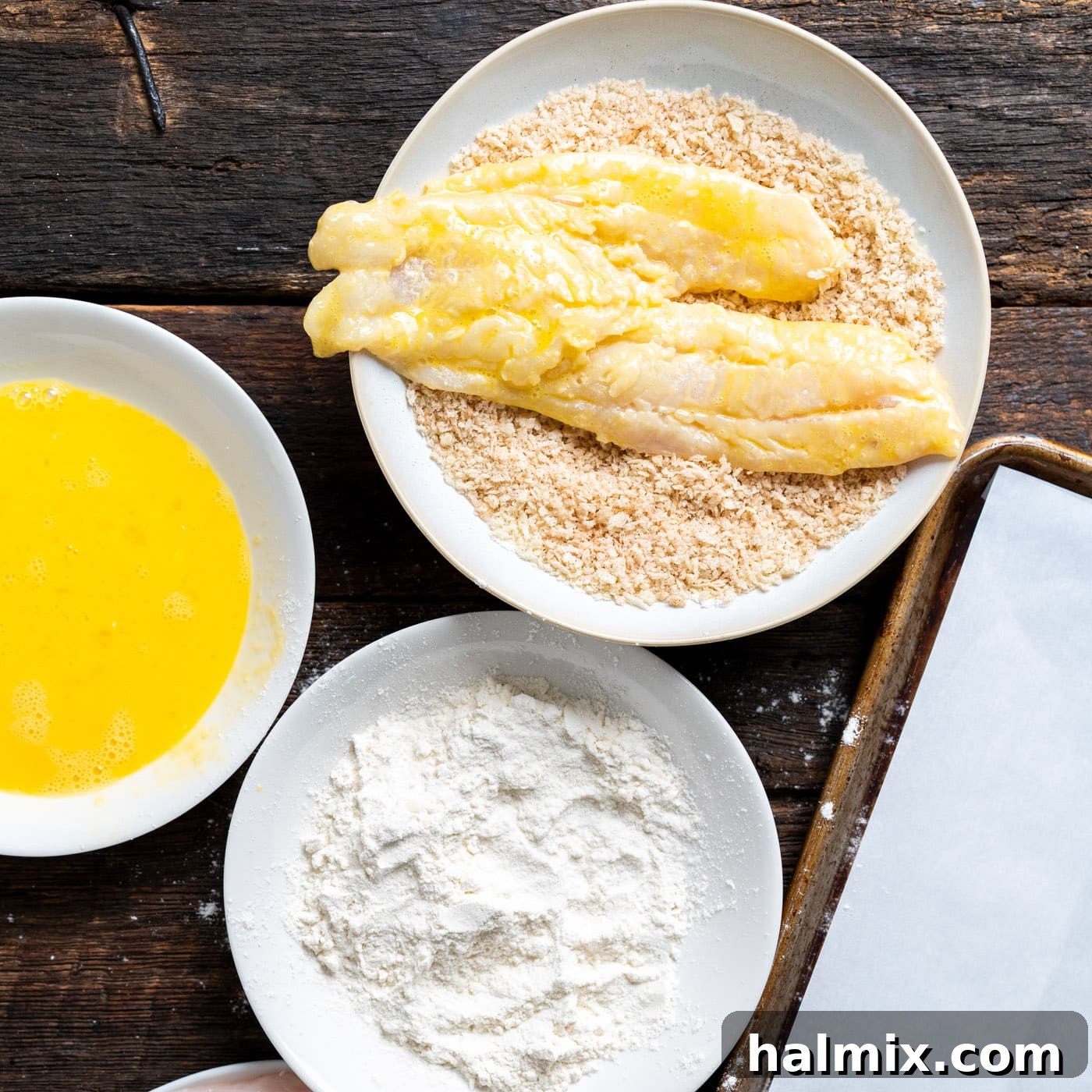 Coating cod fillets in the seasoned panko breadcrumbs for a crispy finish