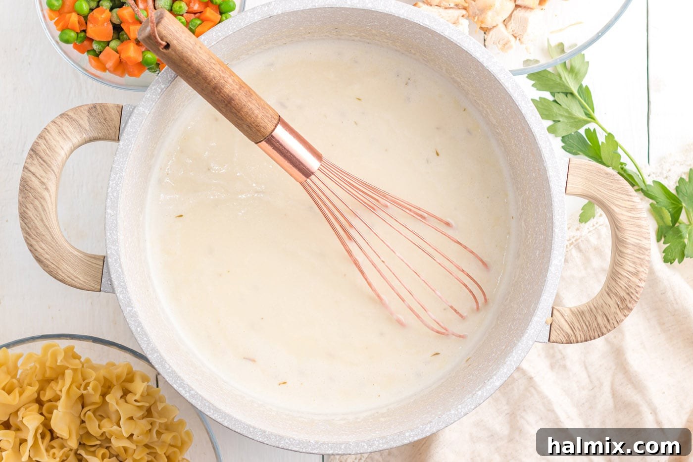 Creamy Chicken Noodle Delight 9 Cooked egg noodles being stirred into the creamy sauce in a large pot.