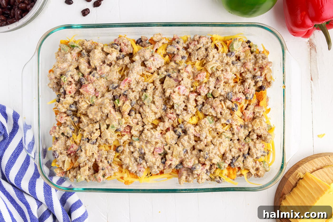 The second half of the ground beef mixture layered over cheese and Doritos.