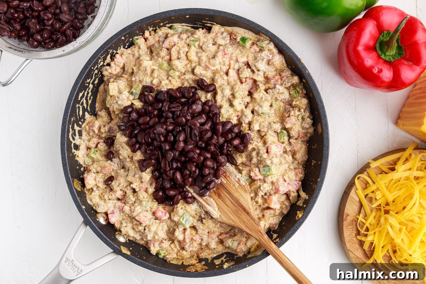 Ground beef mixture combined with black beans in a skillet.