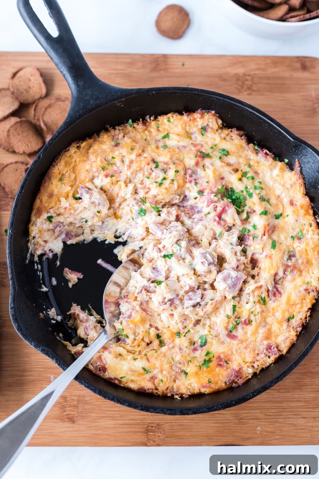 Warm Reuben Dip served in a cast iron skillet, garnished with fresh parsley.