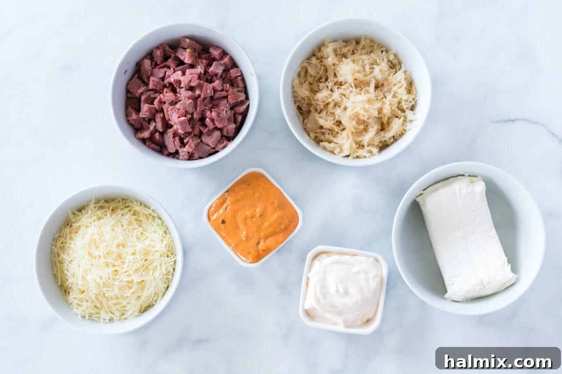 All ingredients for Reuben Dip laid out on a wooden board: cream cheese, corned beef, Swiss cheese, sauerkraut, mayonnaise, and Thousand Island dressing.
