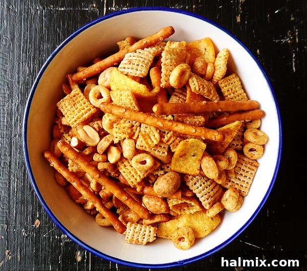 A closer overhead shot of a bowl of Taco Chex Mix, highlighting the rich seasoning and mix of cereals and corn chips.
