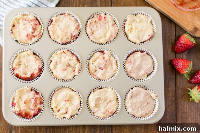 muffin tin with strawberry muffin batter