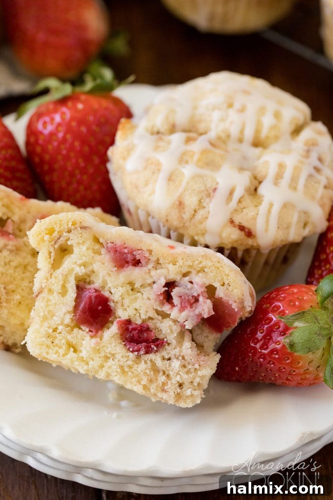 muffin on a plate cut in half showing strawberries inside