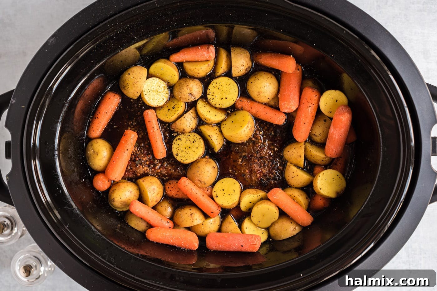 baby carrots and potatoes in a crockpot with corned beef