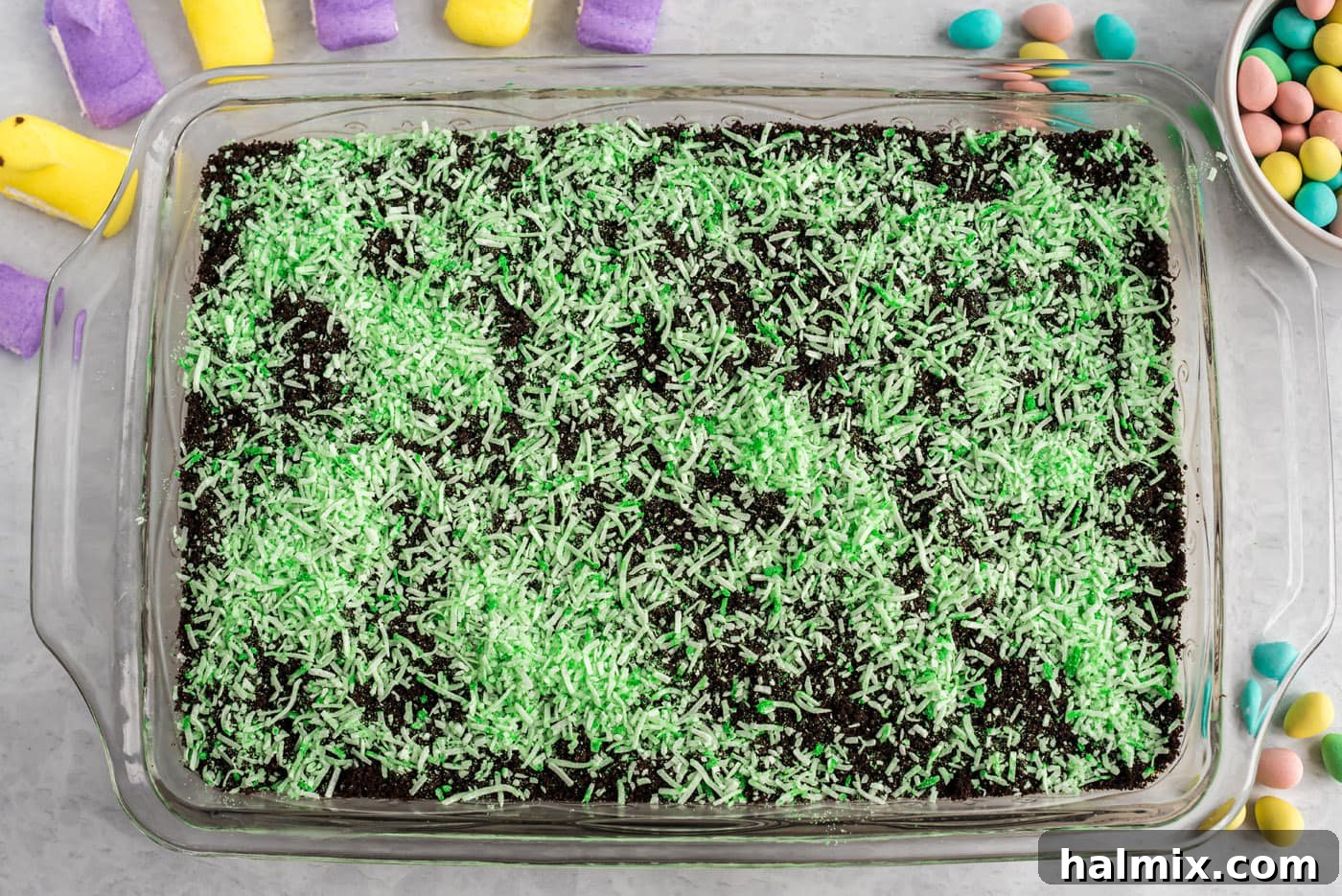 Applying Coconut Grass to the Cake Shredded coconut sprinkled on top of Easter dirt cake
