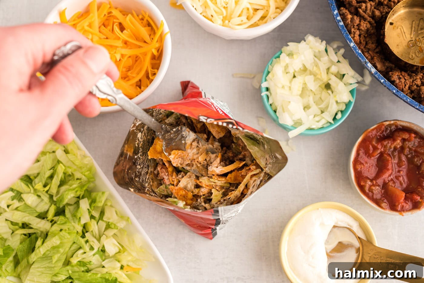 Mixing taco toppings into a bag of chips for Walking Tacos