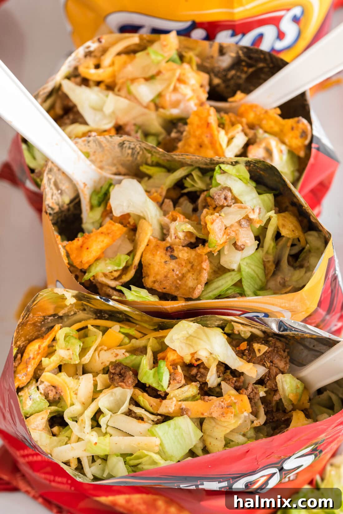 Inside of several Walking Taco bags, showing the mixture of chips, meat, and toppings