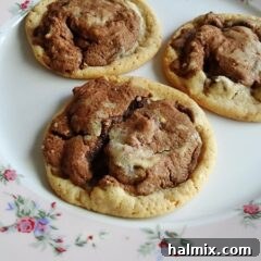 A close up photo of three double stack chocolate chip cookies resting on a plate.
