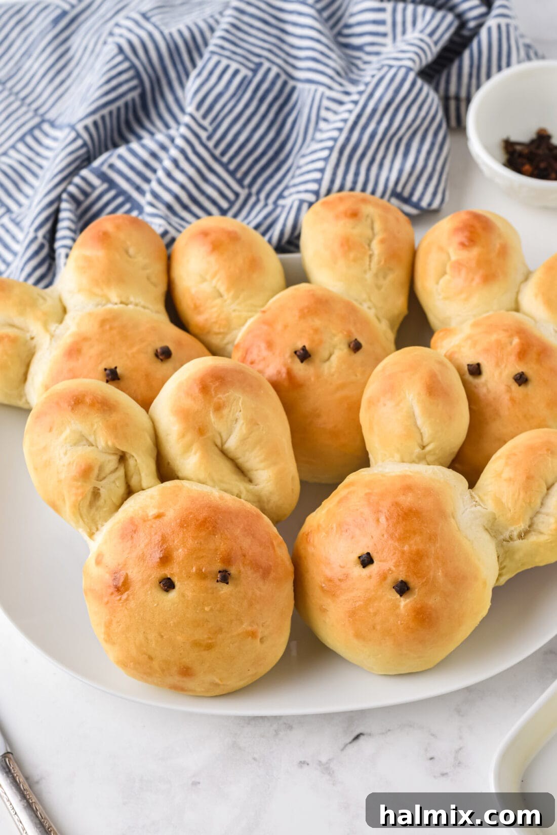 A plate full of golden brown, fluffy Bunny shaped Dinner Rolls, ready to be served.