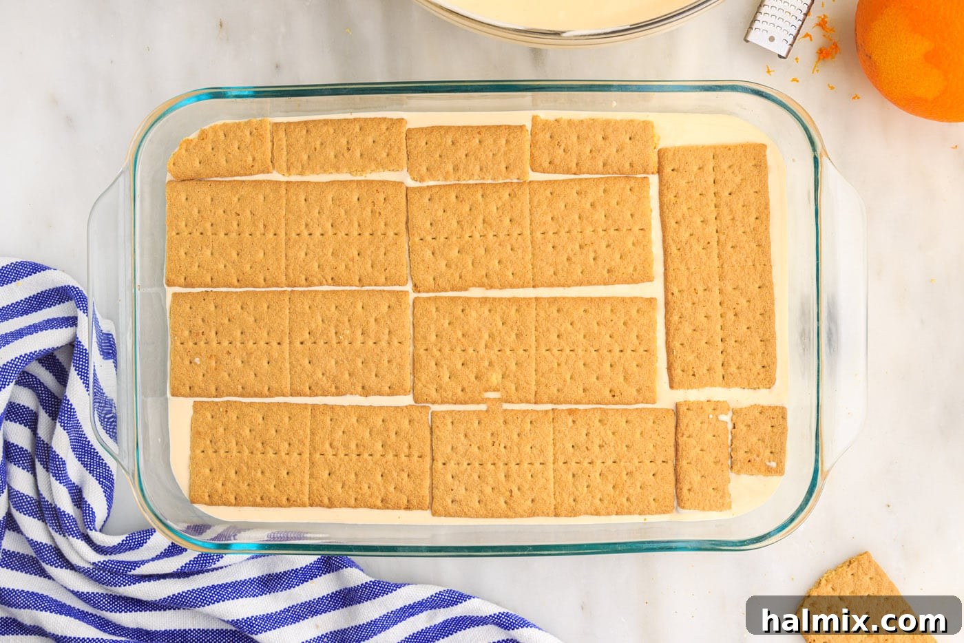 A second layer of graham crackers placed on top of the orange pudding mixture