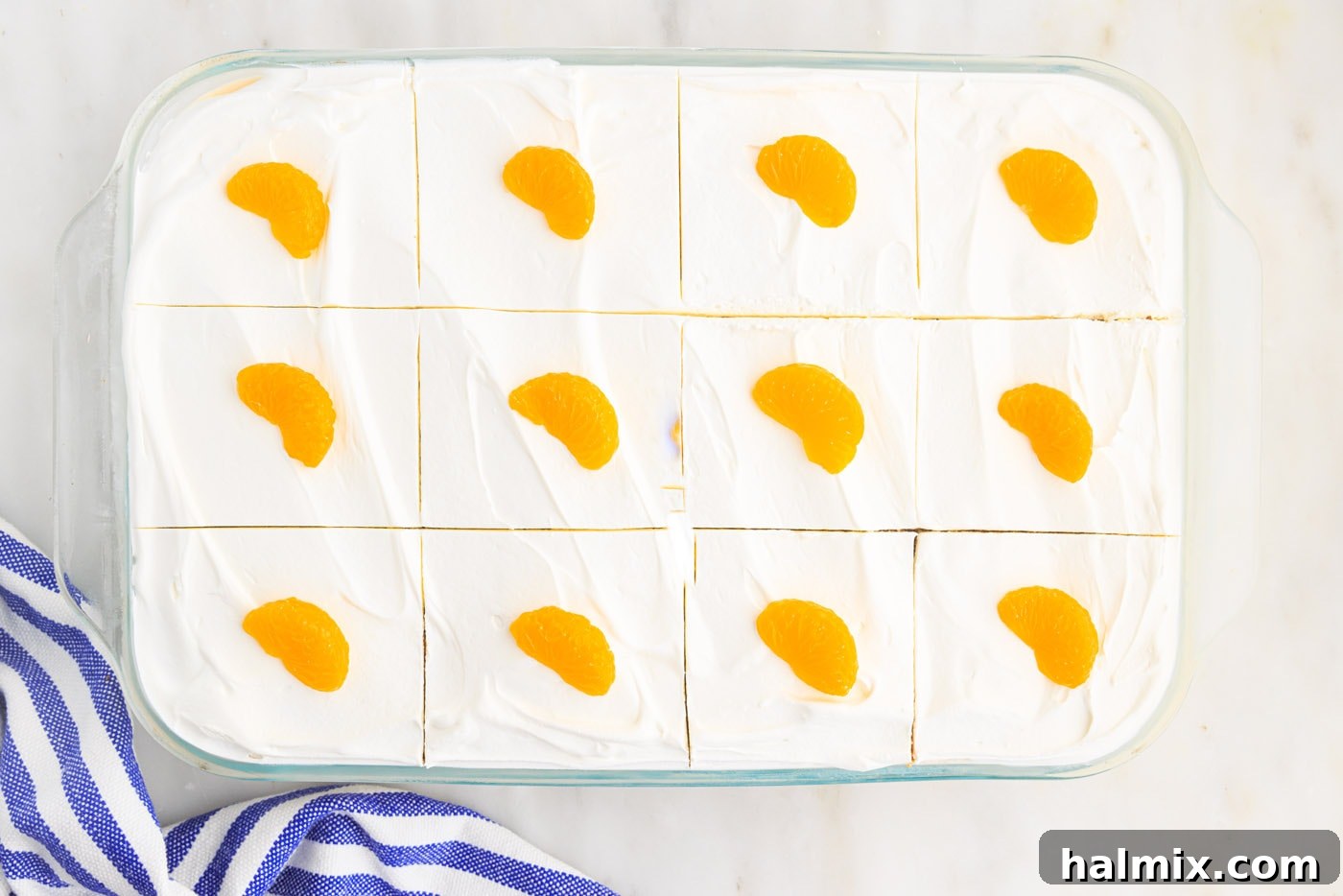 Mandarin orange slices and orange zest as garnish on top of the finished orange icebox cake
