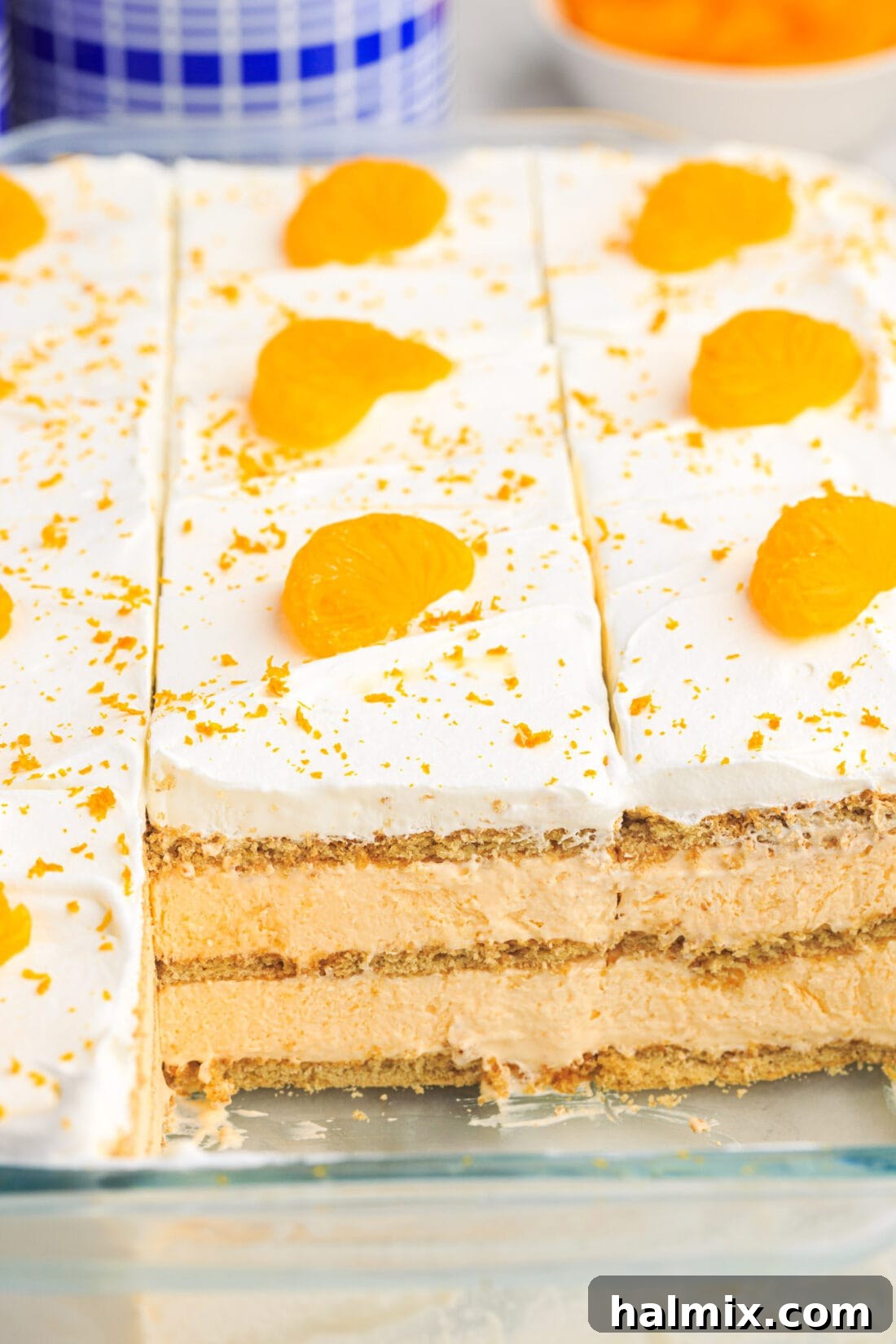 Pan of Orange Icebox Cake neatly cut into pieces, showing its vibrant color and distinct layers