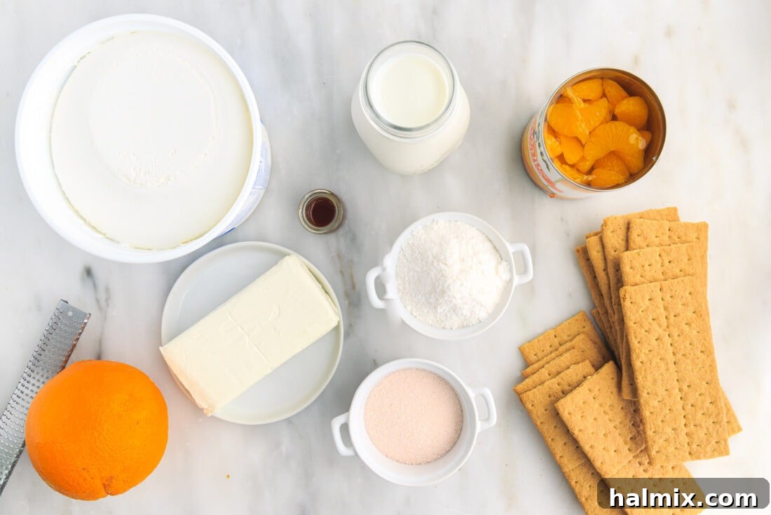 A collection of ingredients for Orange Icebox Cake, including graham crackers, mandarin oranges, cream cheese, and pudding mix