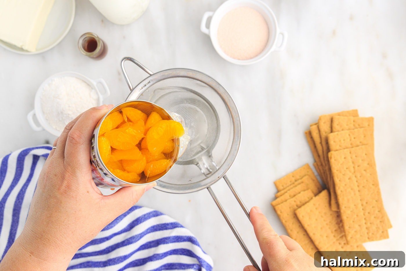 Draining mandarin oranges into a measuring cup to collect the juice