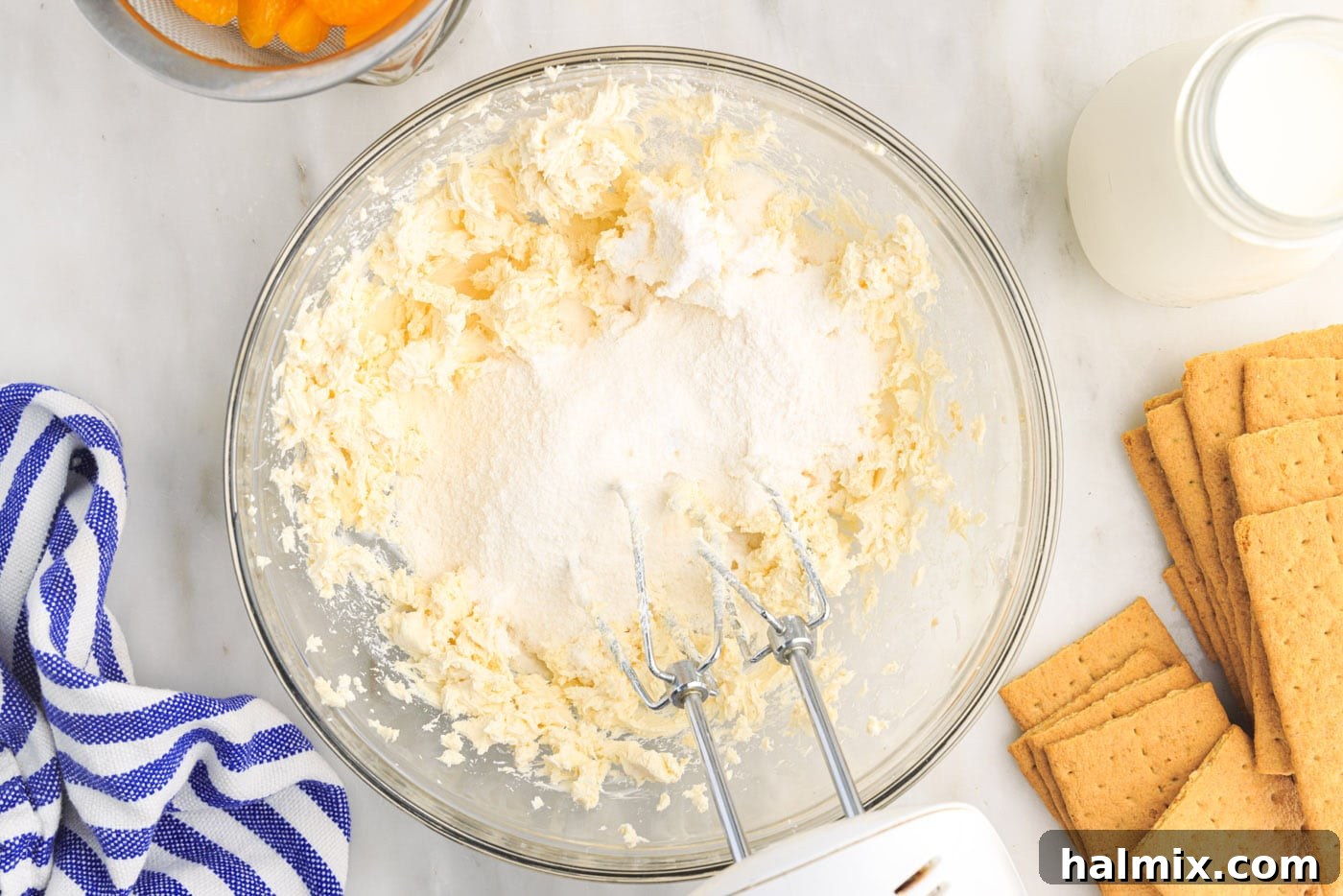 Pudding mix added to the cream cheese in a bowl, followed by pouring milk into the mixture