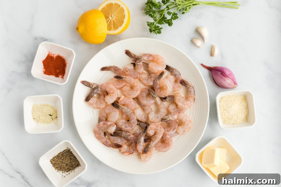 Individual ingredients for sauteed shrimp laid out: shrimp, butter, garlic, shallot, parmesan, paprika, garlic salt, and pepper.